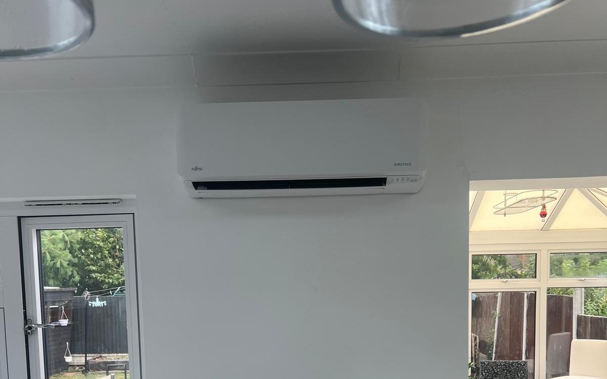 Wall-mounted air conditioning unit installed above the window in a modern kitchen