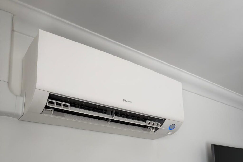 Wall-mounted air conditioning unit installed high on a living room wall